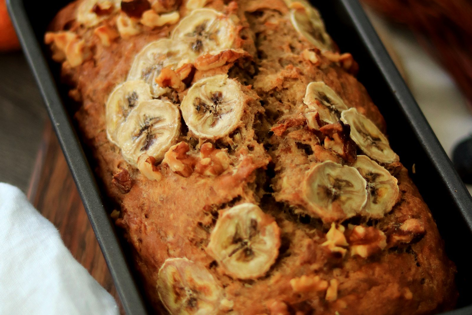A golden loaf of moist banana bread with a crackly top, sliced to show the tender crumb