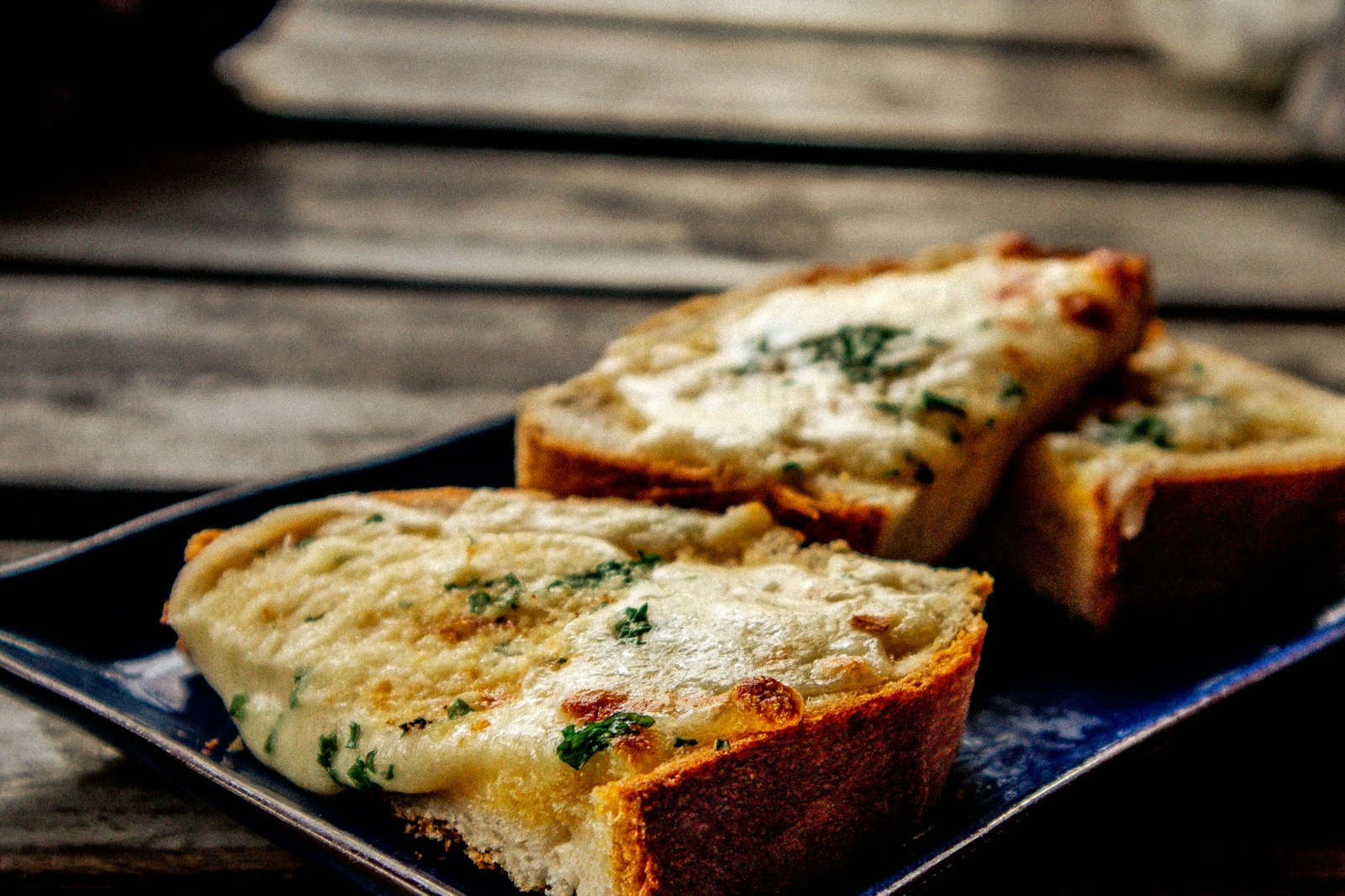 Overhead view of cheesy Christmas tree pull-apart bread with a pulled piece stretching melted mozzarella