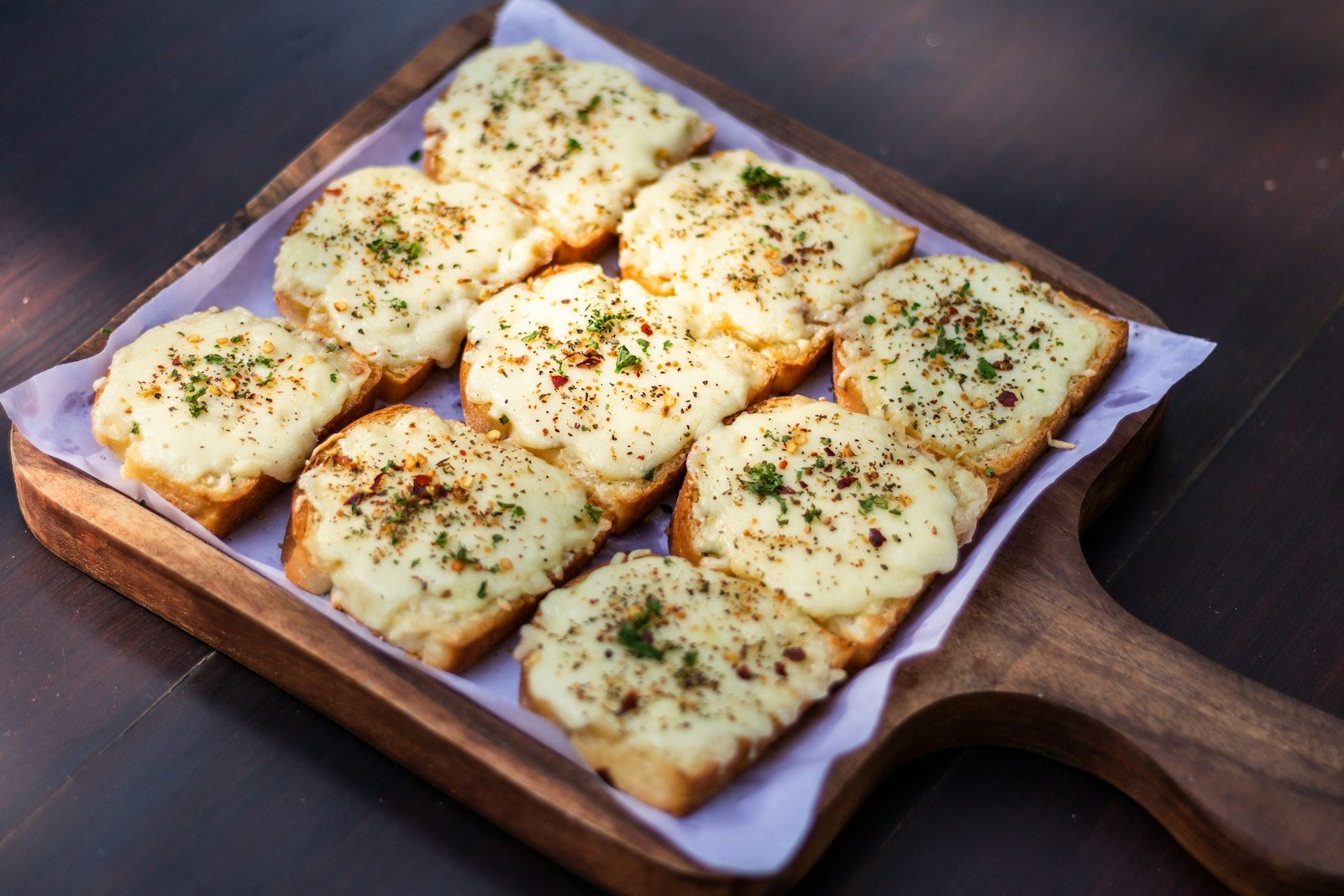 Cheesy garlic Christmas tree pull-apart bread brushed with herb butter, with a bowl of warm marinara for dipping