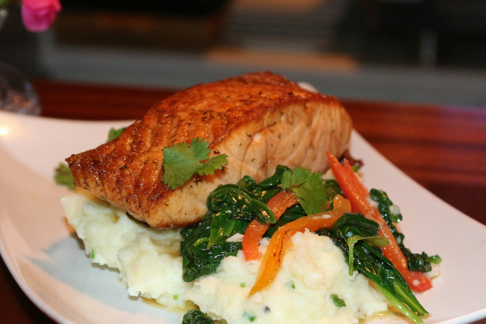 Seared Tuscan salmon served with spinach over creamy mashed potatoes