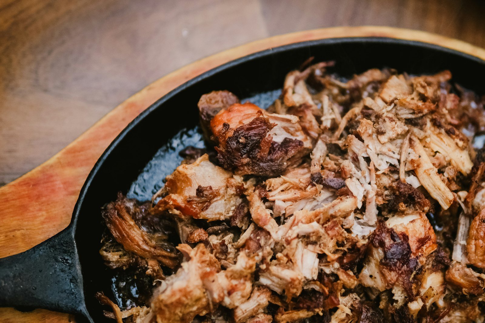 Two forks shredding tender crockpot pulled pork in the slow cooker, with the smoky spice crust and juicy strands visible