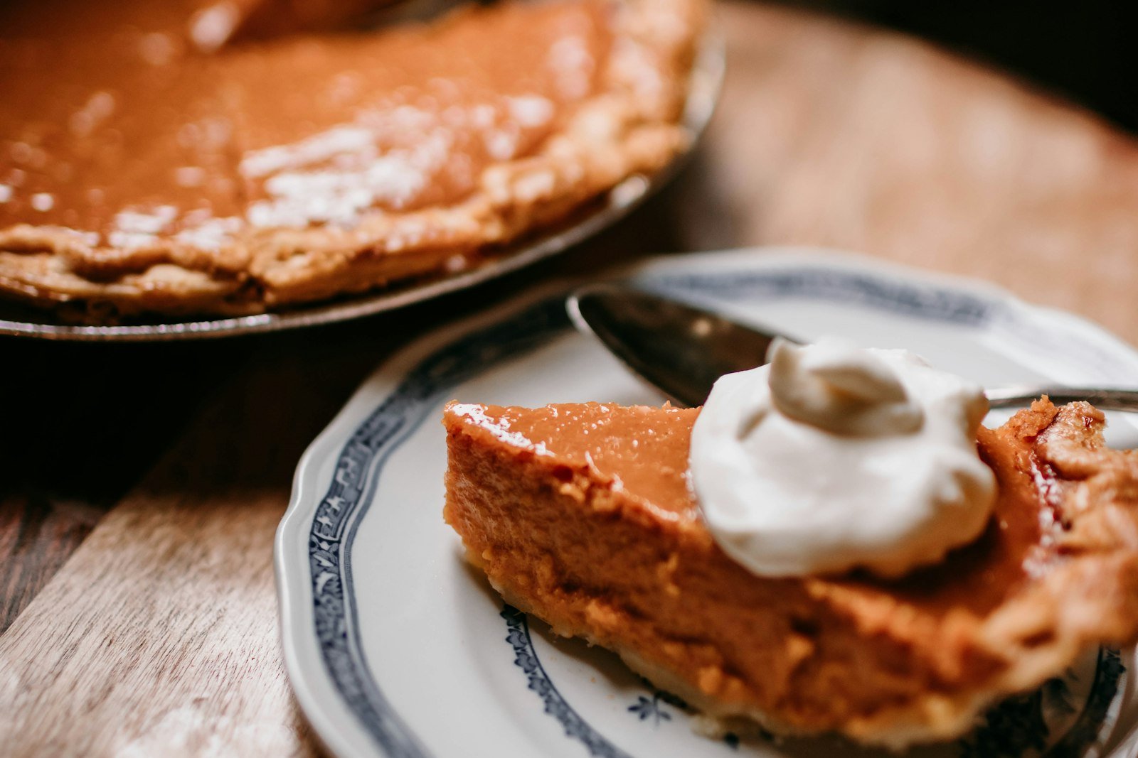 A slice of classic pumpkin pie with a smooth, creamy filling and a crisp golden crust