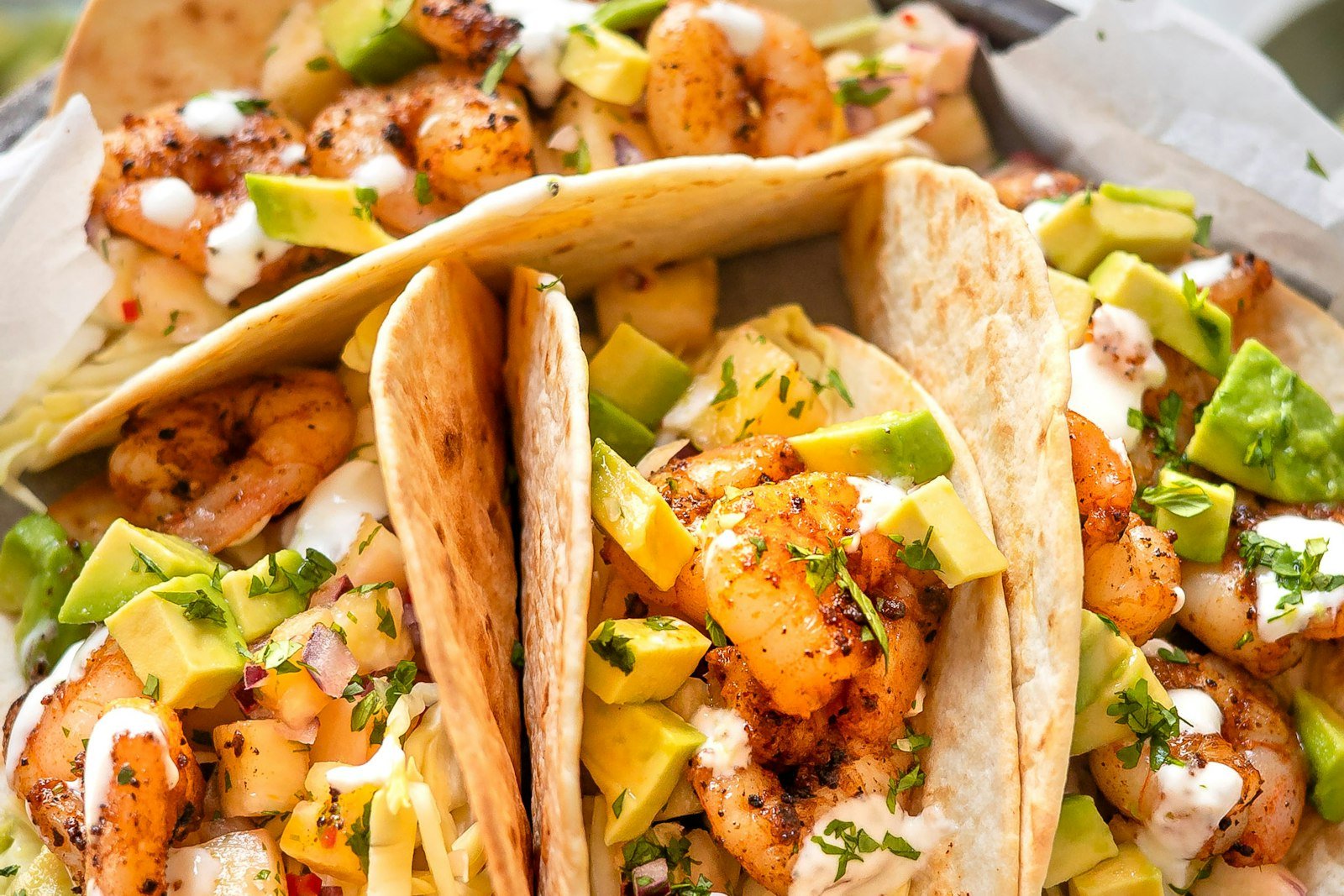 Crispy fish tacos in warm tortillas topped with lime slaw, chipotle crema, cilantro and avocado