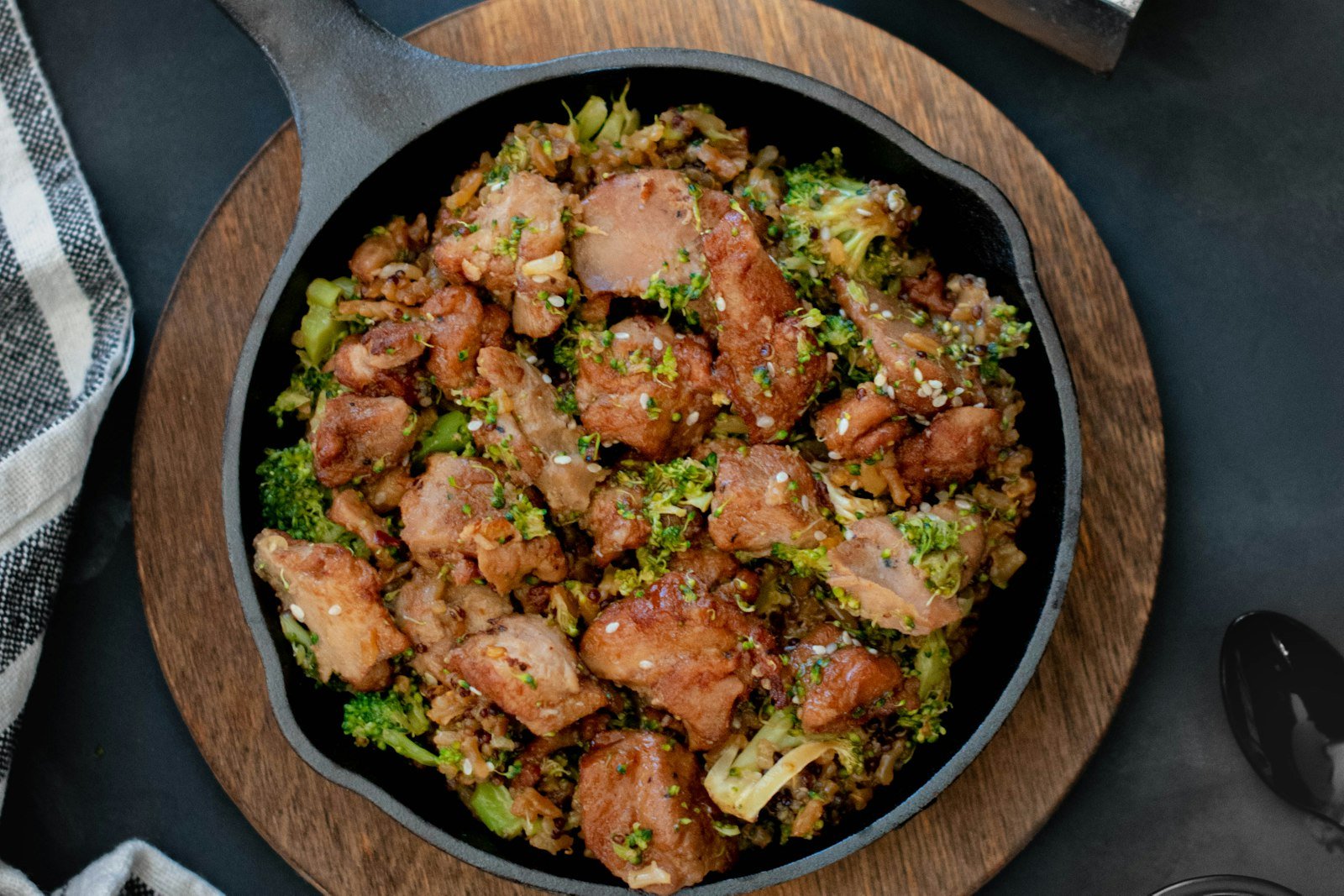 Close-up of dirty cabbage being stirred in a cast-iron skillet, showing browned andouille coins, ground beef and tender green cabbage