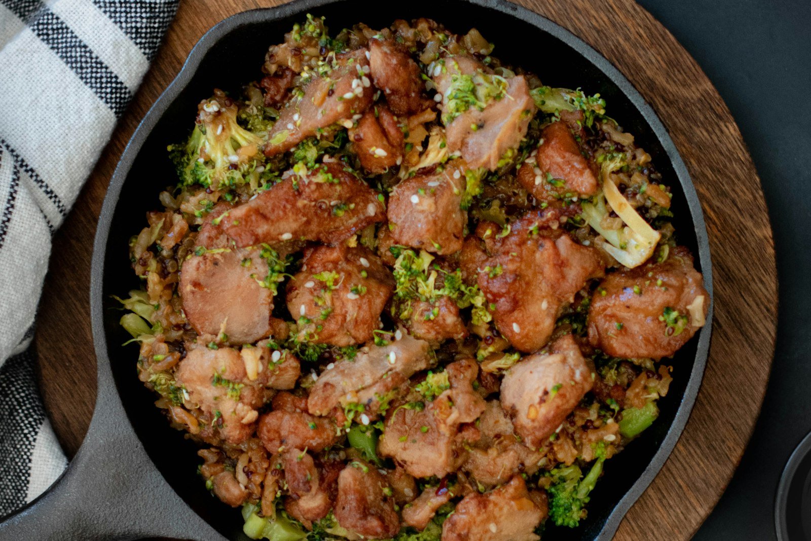 A large skillet of dirty cabbage with browned andouille sausage, ground beef, peppers and tender cabbage, topped with sliced green onions