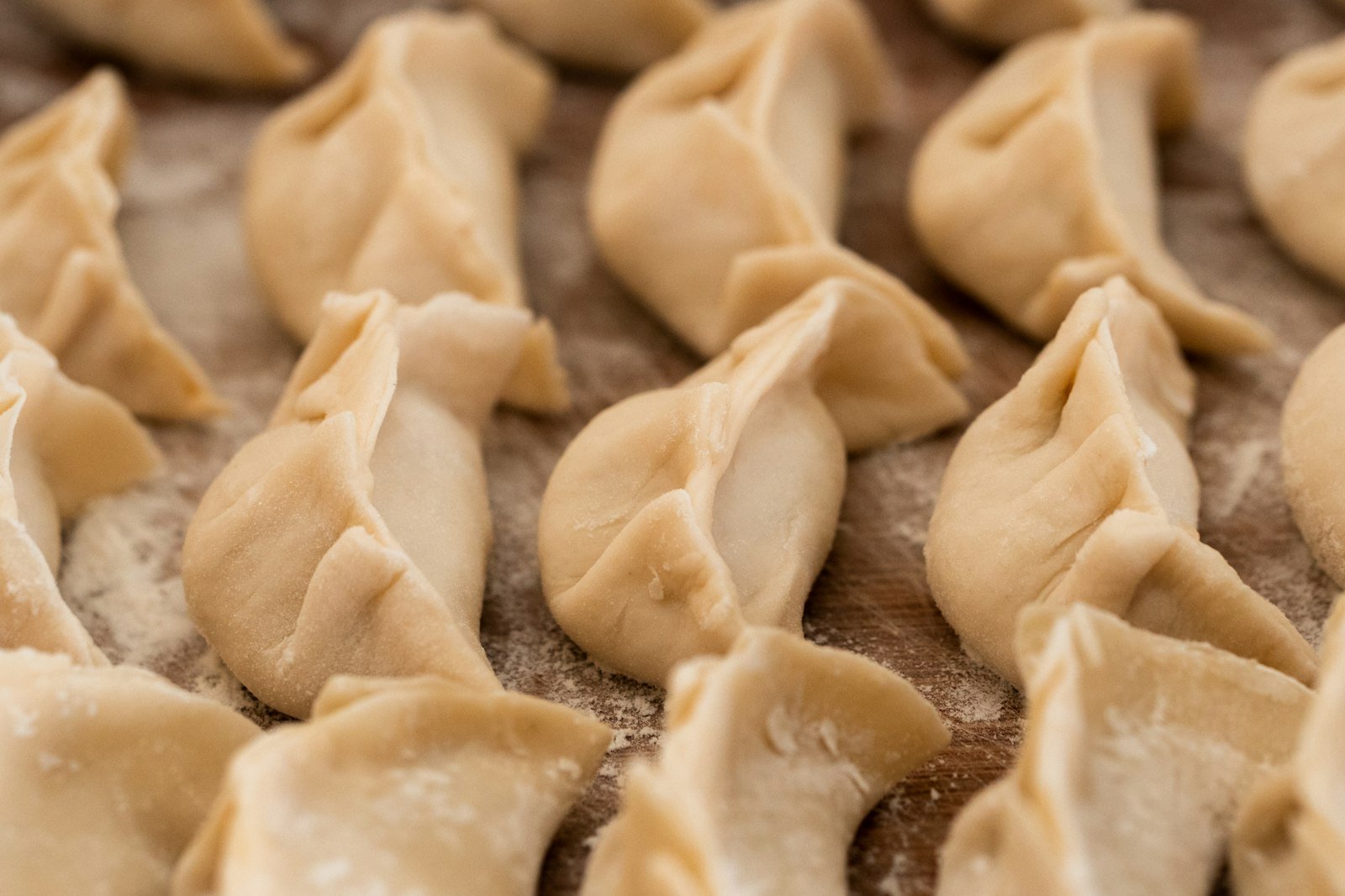 A serving of dumpling bake lifted with a spatula, showing golden potstickers, tender broccoli and bok choy coated in glossy ginger garlic sauce
