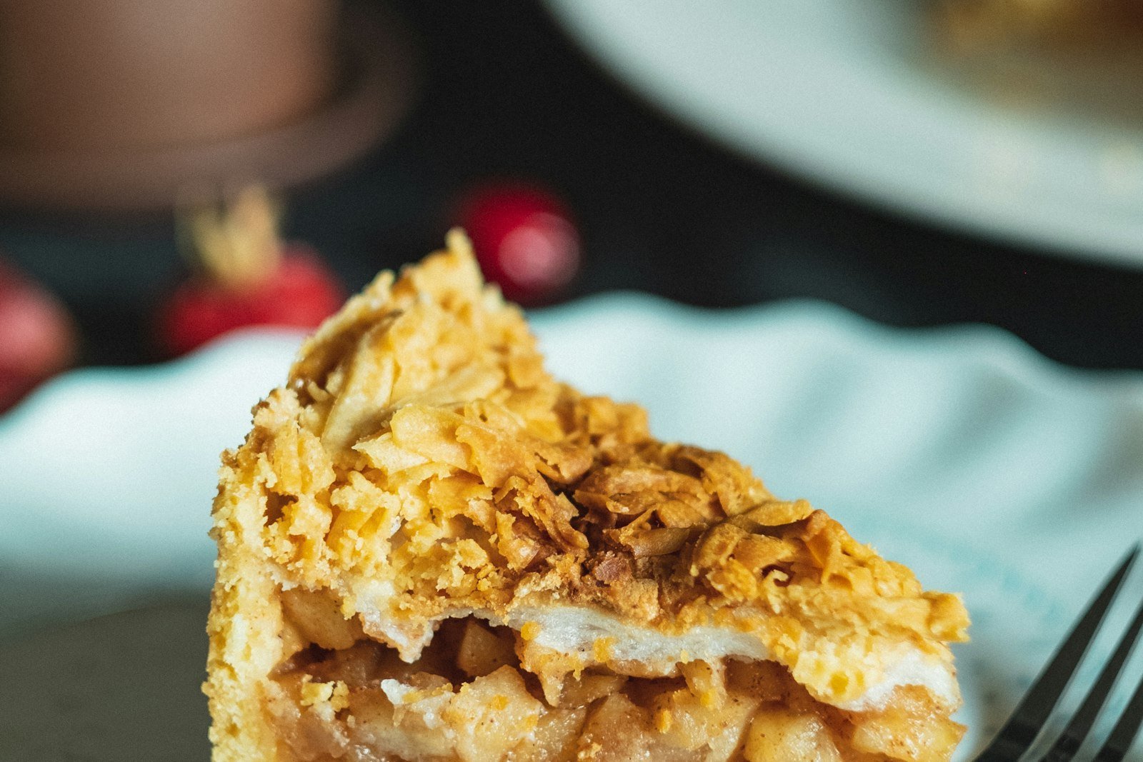 A slice of dutch apple pie with tender spiced apples under a golden crumb topping