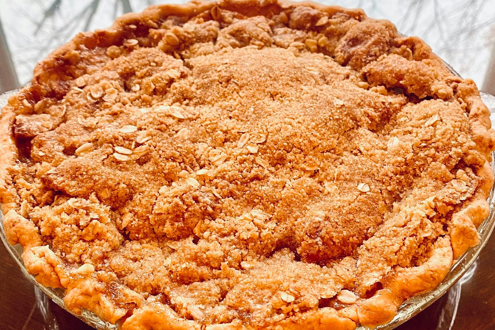 A golden dutch apple pie with a thick cinnamon crumb topping and juicy spiced apples underneath