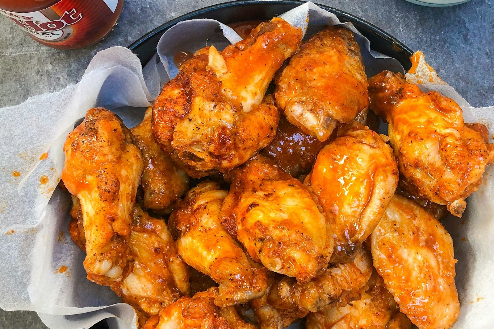 A pile of crispy baked garlic parmesan wings with parsley and extra grated parmesan