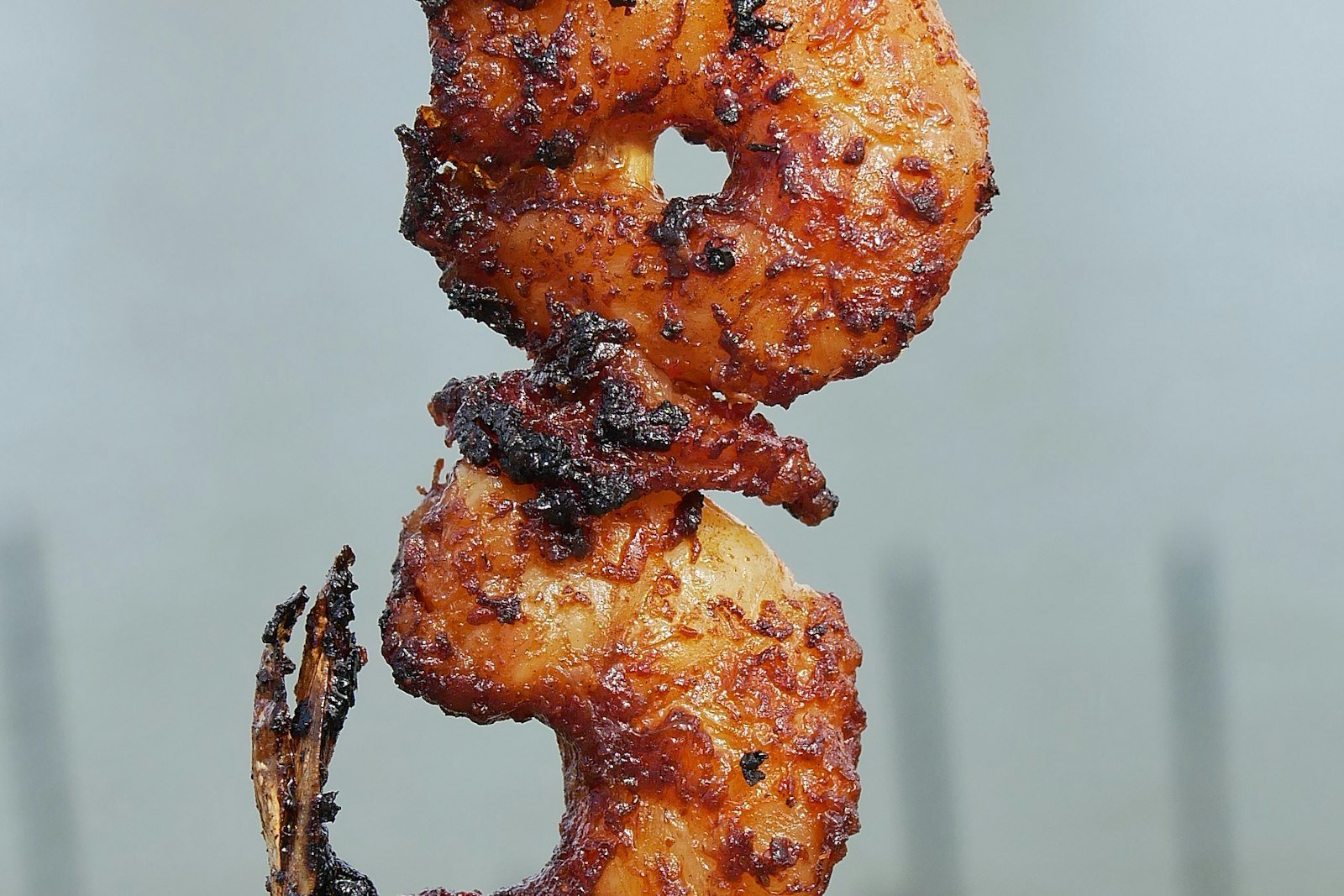Honey garlic shrimp skewers glazed and charred, served on a platter with lime wedges and sesame seeds