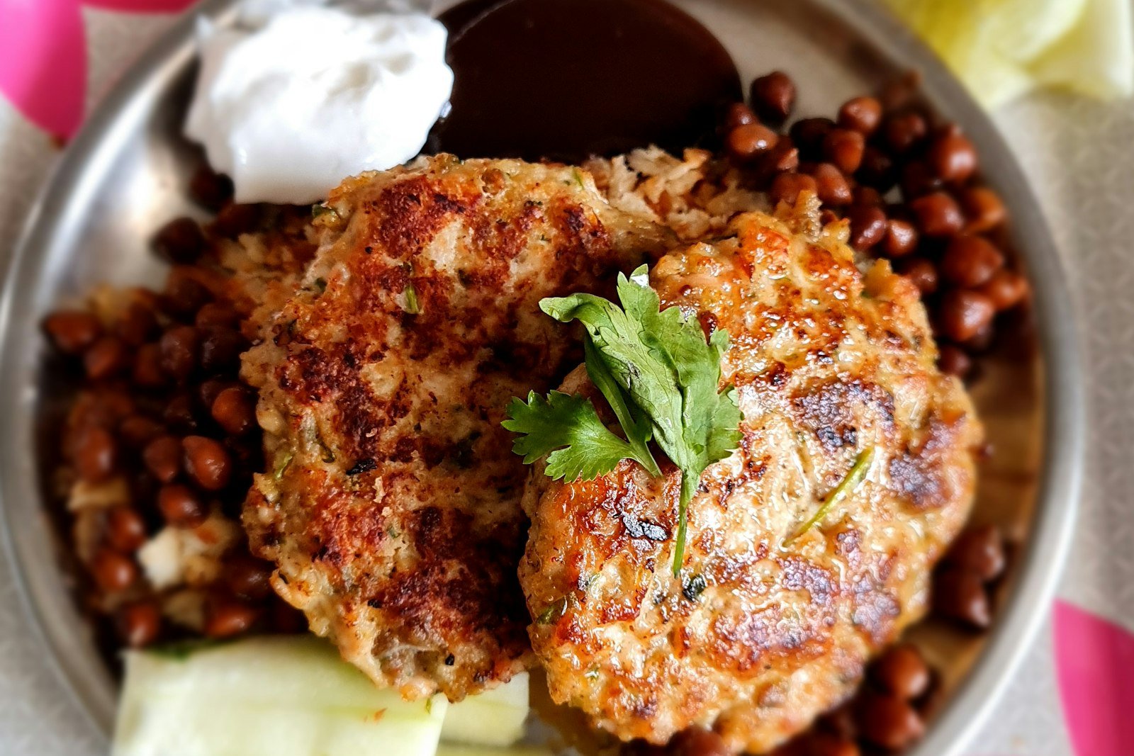 Crispy golden salmon cakes in a skillet, one turned to show the flaky pink salmon inside
