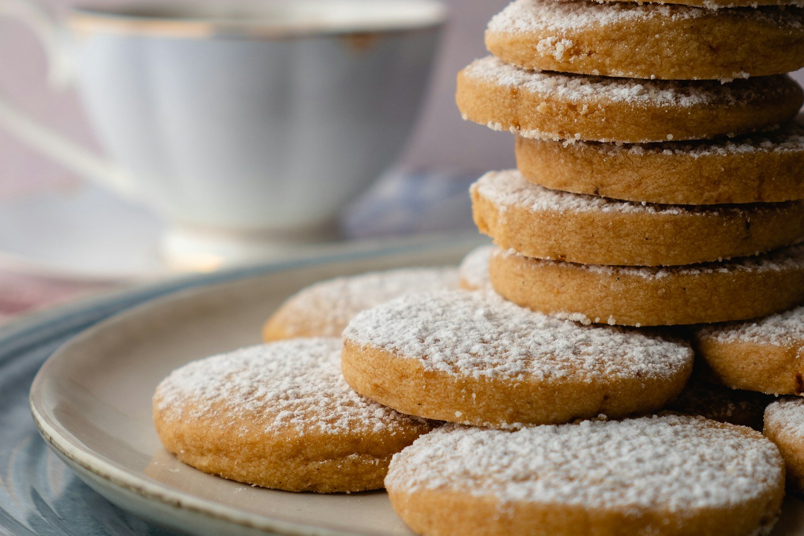 Golden-edged butter shortbread cookies dusted with sugar on a parchment-lined holiday platter