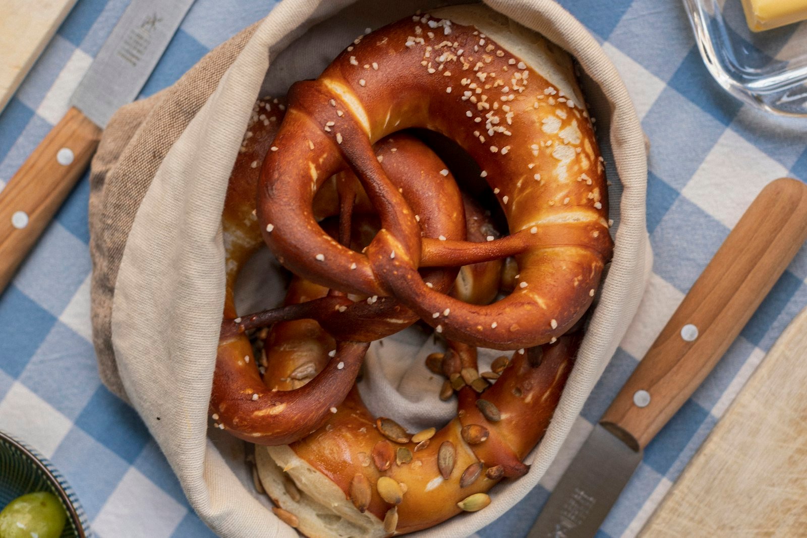 Golden spinach cheese pretzel wreath arranged around a small bowl of dip on a baking sheet